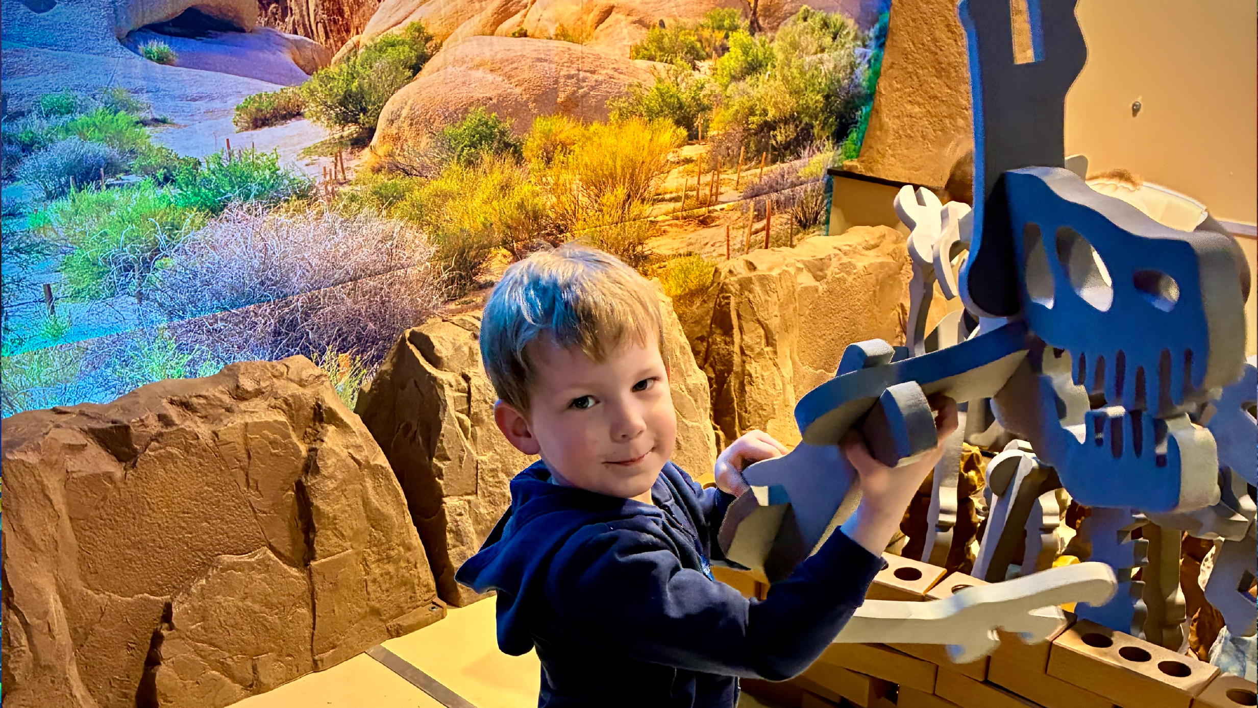 Child assembling a dinosaur skeleton at the David Digs Dig Pit